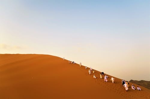 Photo of People Walking on Desert
