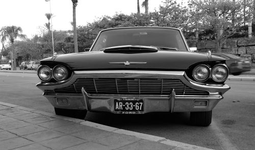 Free Black and white image of a vintage Ford Thunderbird car parked on a street in Benalmádena, Spain. Stock Photo