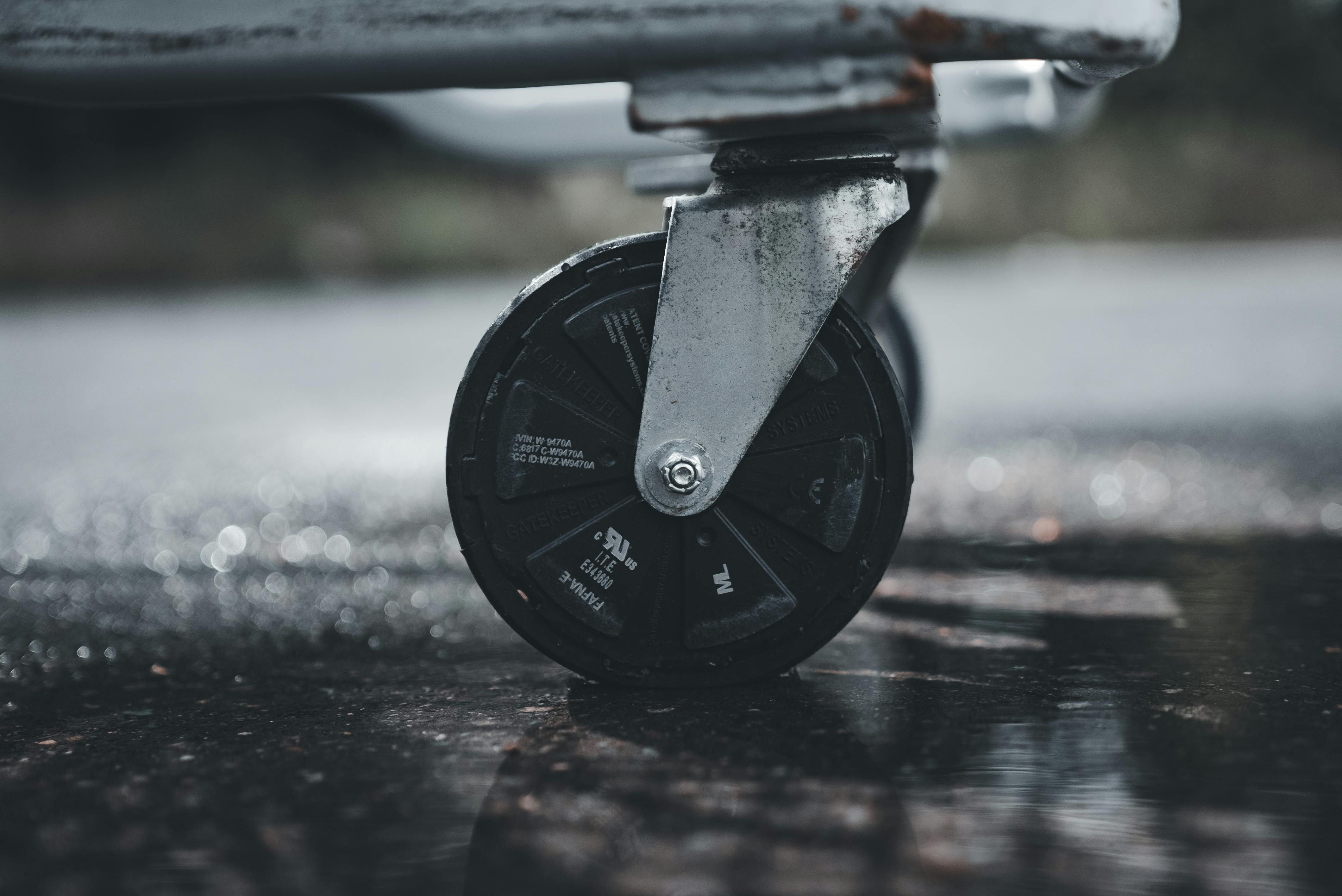 Detail von feststellbaren Möbelrollen unter einem Küchenwagen auf Hartboden