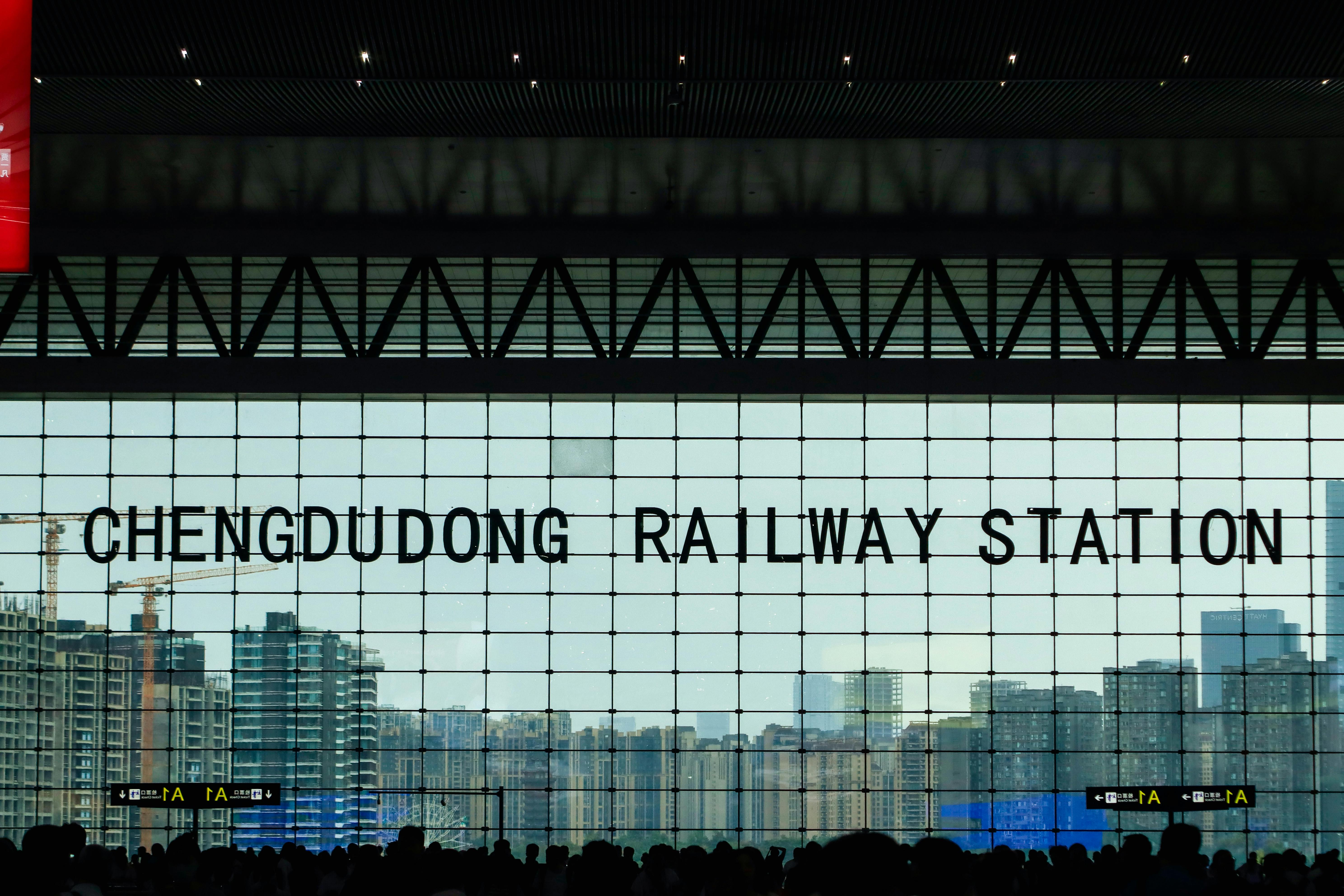 A view from inside Chengdu East Railway Station showcasing the city skyline through large glass windows.