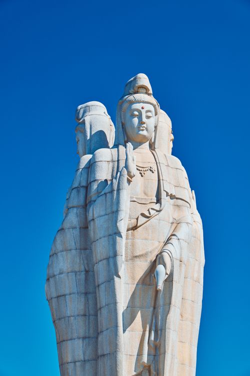 Free A stunning white stone statue captures attention against a vibrant blue sky, showcasing intricate details. Stock Photo