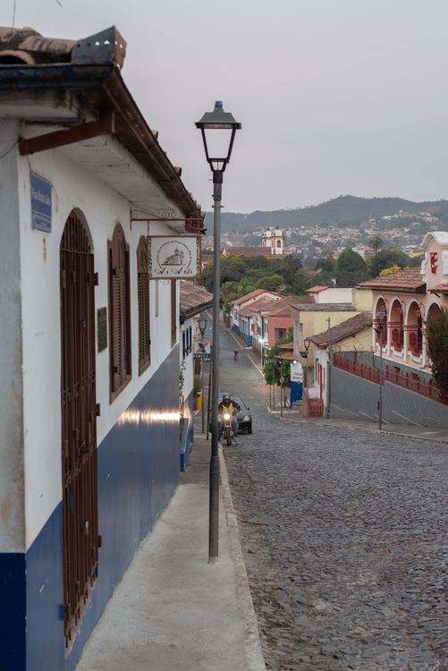 Free Cobblestone street in Sabará, Brazil, showcases colonial architecture at dusk. Stock Photo