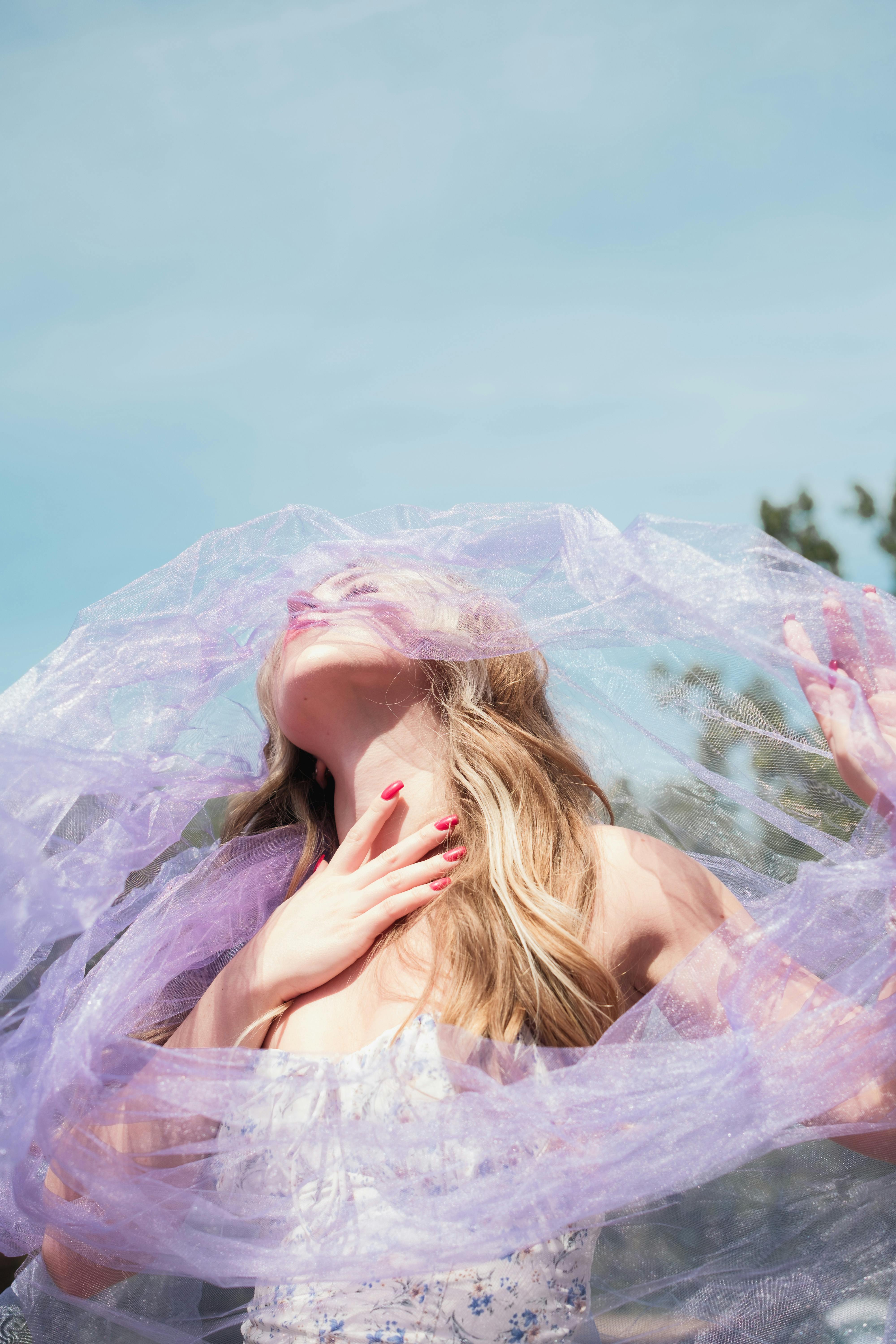 一幅异想天开的肖像，描绘了一位笼罩在淡紫色薄纱下的女人