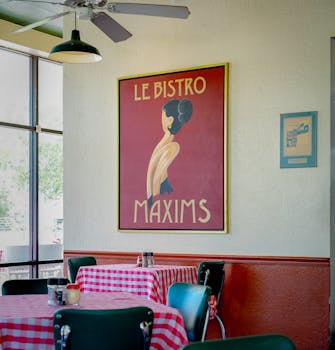 Cozy bistro in Houston with vintage poster and checkered tablecloths.