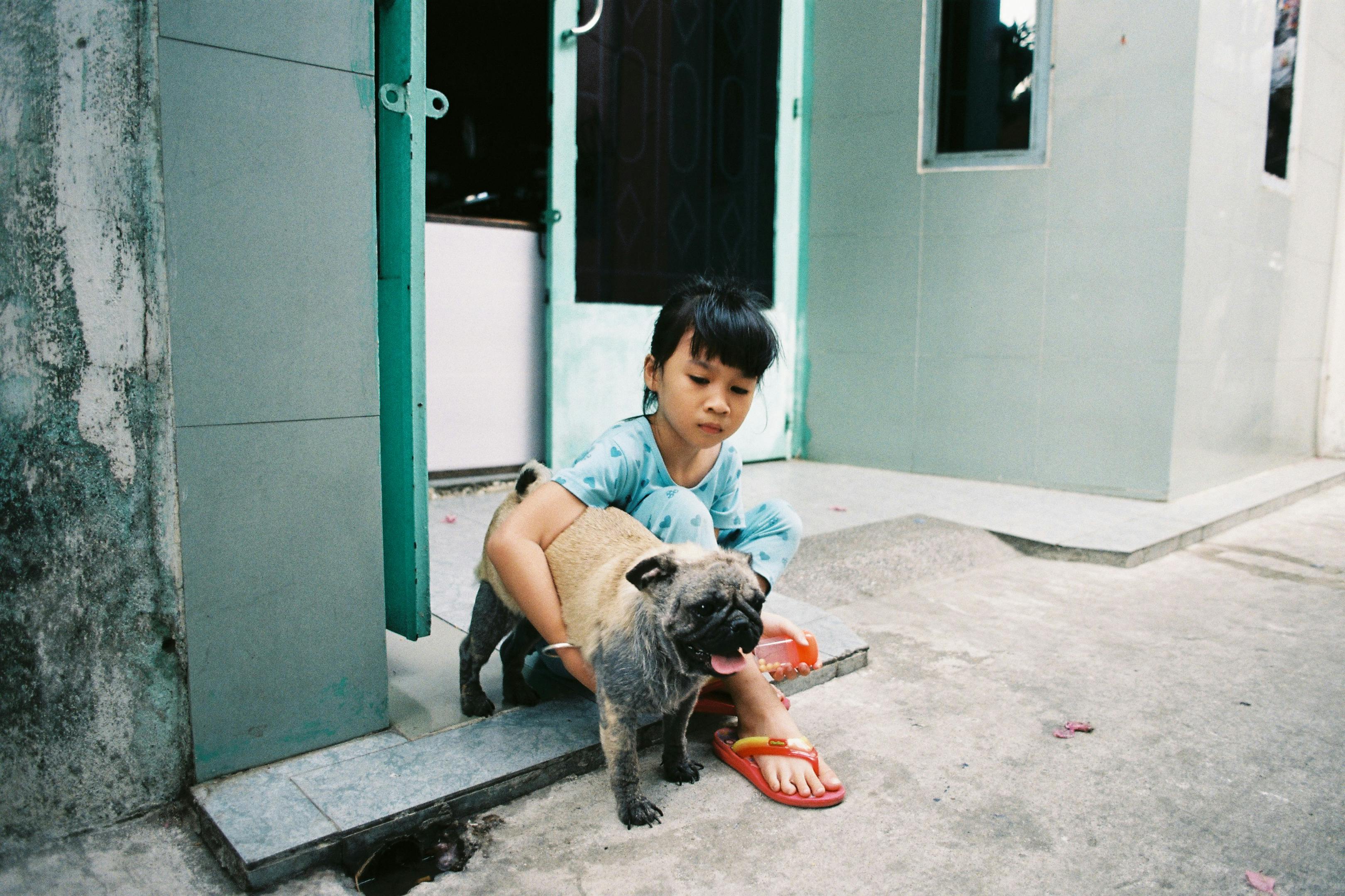 Child with Pug Dog on Doorstep in Ho Chi Minh City