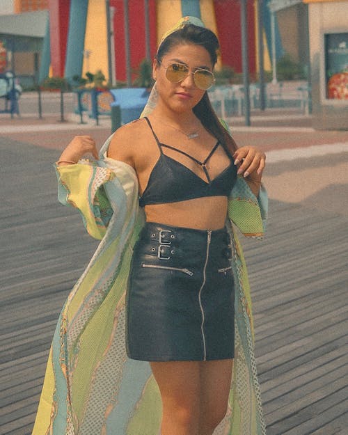 Photo of Woman in Black Bra, Black Leather Skirt, and Sunglasses Posing