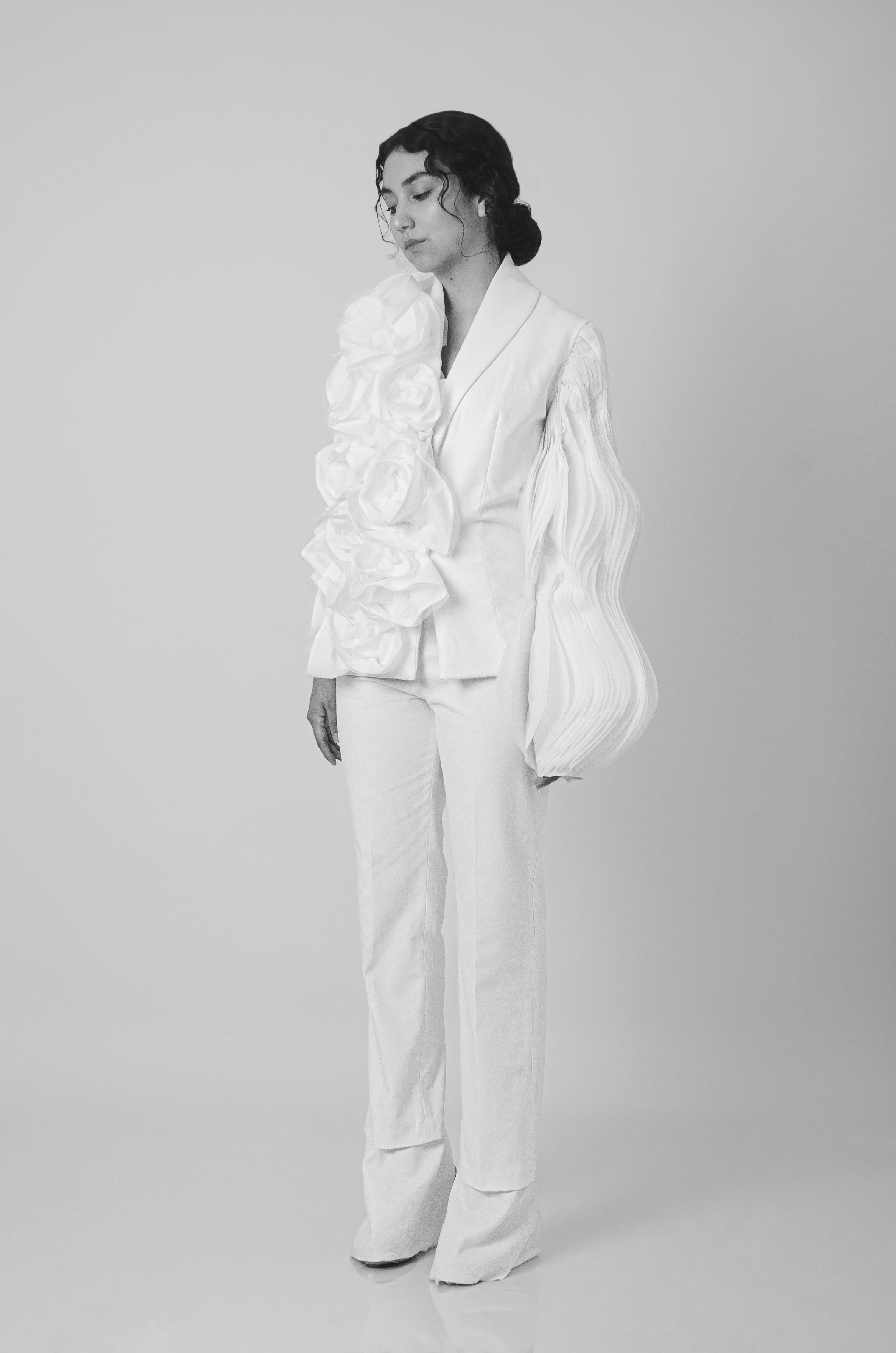 Stylish black and white portrait featuring unique fashion with sculptural elements.