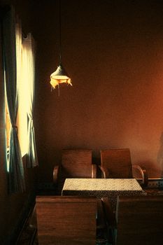 Warm rustic dining room interior with vintage pendant light and wooden furniture, creating a cozy atmosphere.
