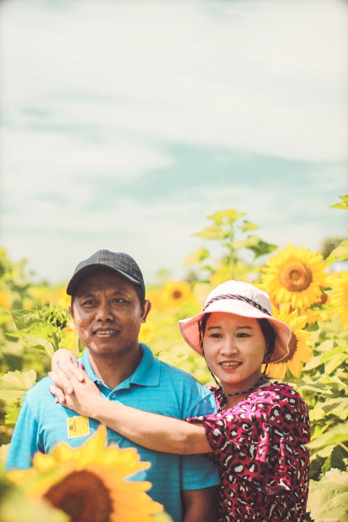 gratis Aziatisch Paar Op Een Veld Met Zonnebloemen Stockfoto