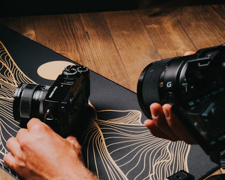 Hands capturing close-up shots with cameras on a wooden and artistic surface.