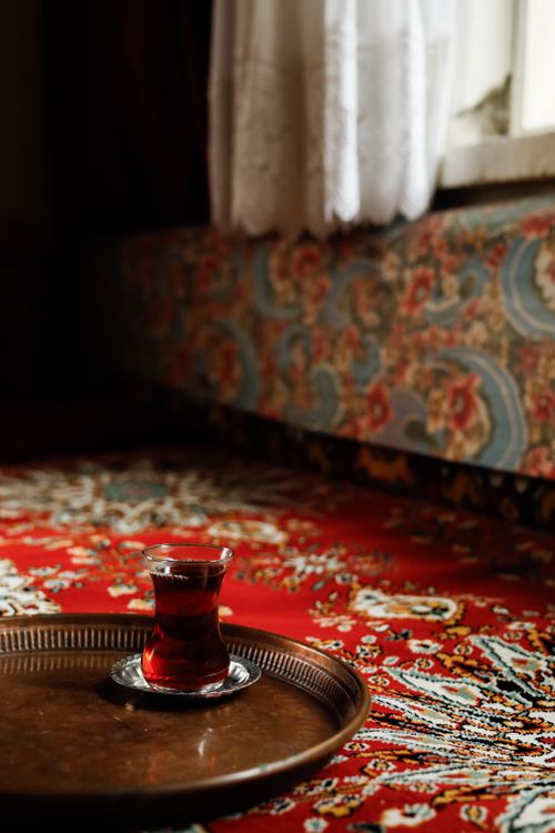 Free A cup of Turkish tea sits elegantly on an ornate carpet, exuding warmth and culture. Stock Photo