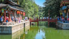 游客在北京颐和园探索风景如画的桥梁和传统建筑