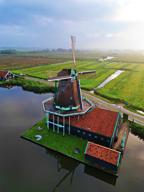 Free Scenic aerial view of a traditional Dutch windmill in Amsterdam's countryside. Stock Photo