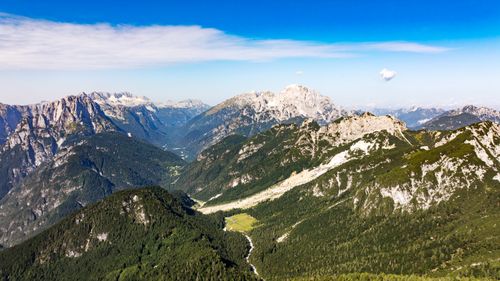 Free Stunning aerial view of the Julian Alps in Slovenia, showcasing lush green valleys and rugged peaks under a clear blue sky. Stock Photo