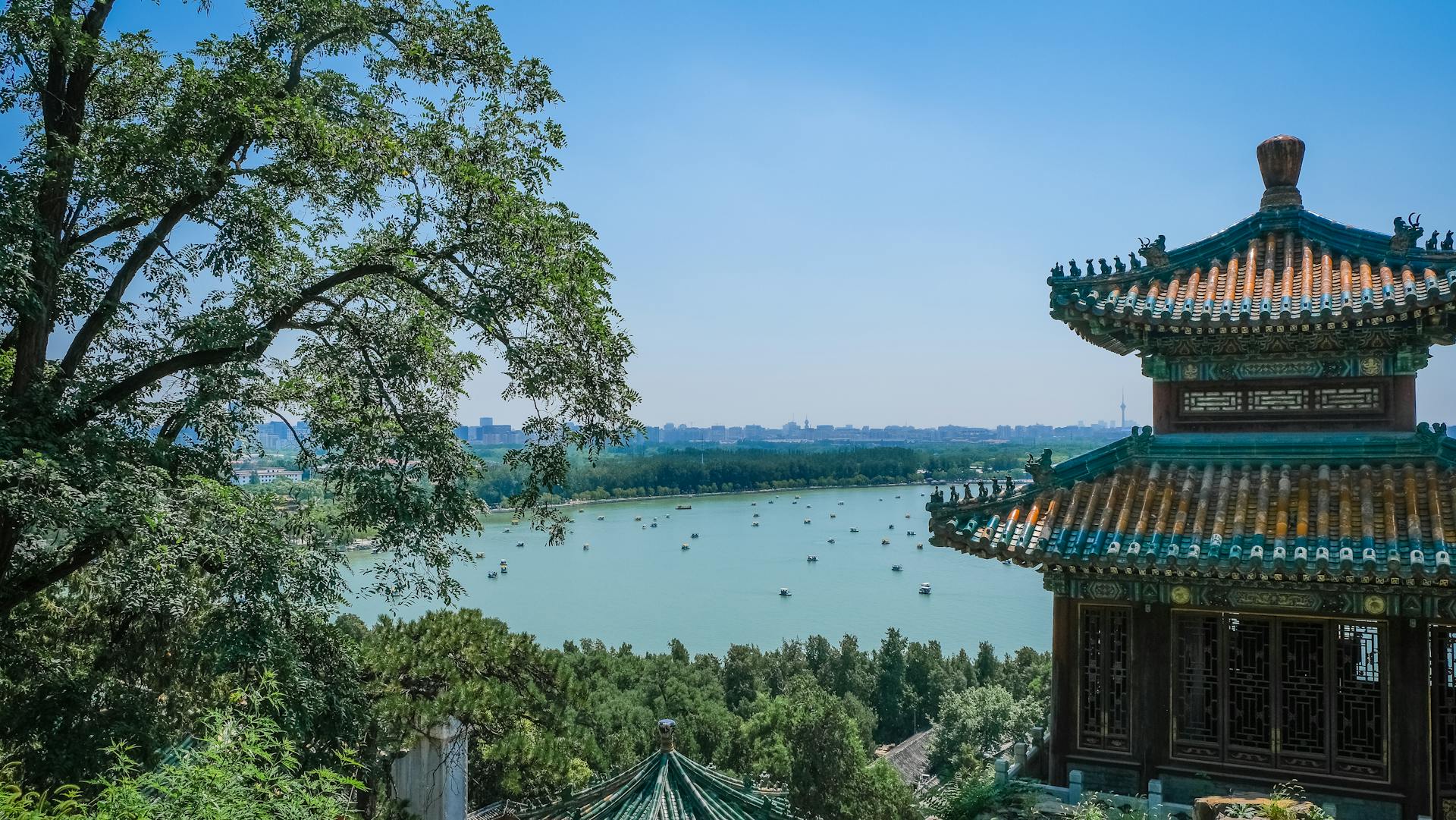 Multicolored Concrete Building  With A Lake View Showing The Distinct Architectural Design Of Ancient China