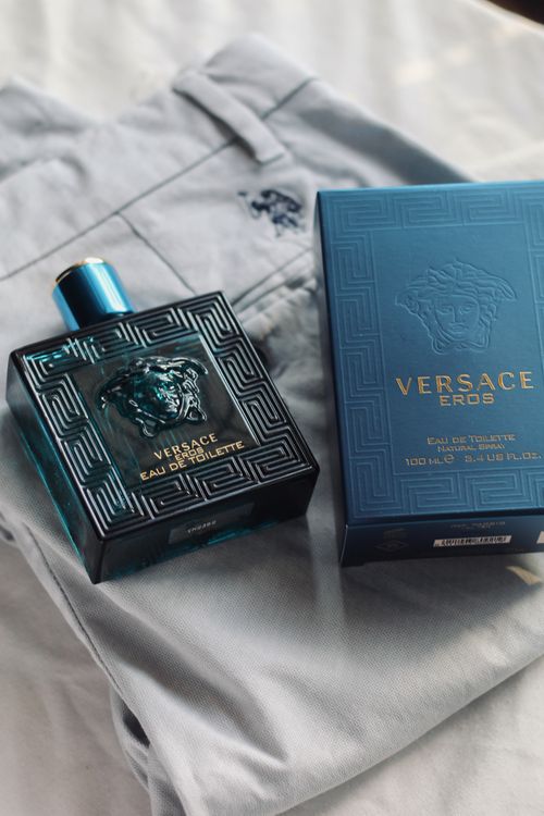 Free Versace Eros perfume bottle and box displayed on stylish light fabric, capturing luxury. Stock Photo