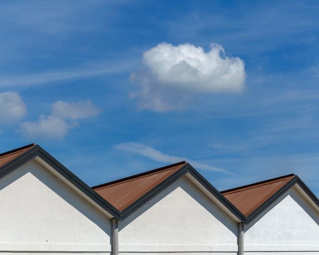 Gable shingle roofs Gable roofs with sharp angles under a blue sky with soft clouds