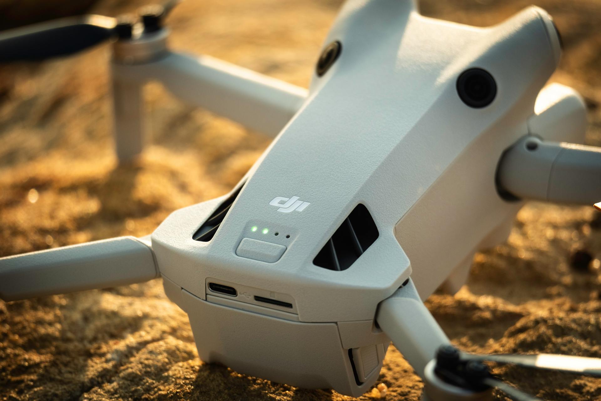 Close-up of DJI Drone on Sandy Terrain at Sunrise