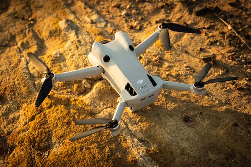 Free Aerial drone resting on rocky ground during a golden sunrise in Springfield, QLD, Australia. Stock Photo