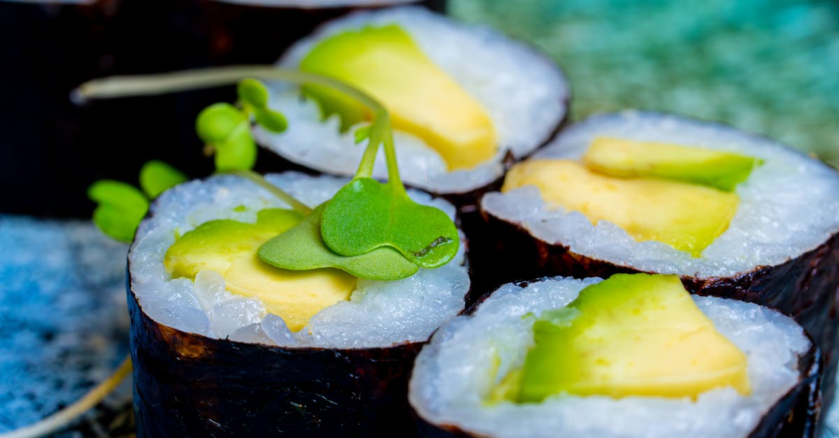 Photo by Nano Erdozain Vibrant vegetarian sushi rolls with avocado on a decorative blue plate. Perfect for healthy food themes.