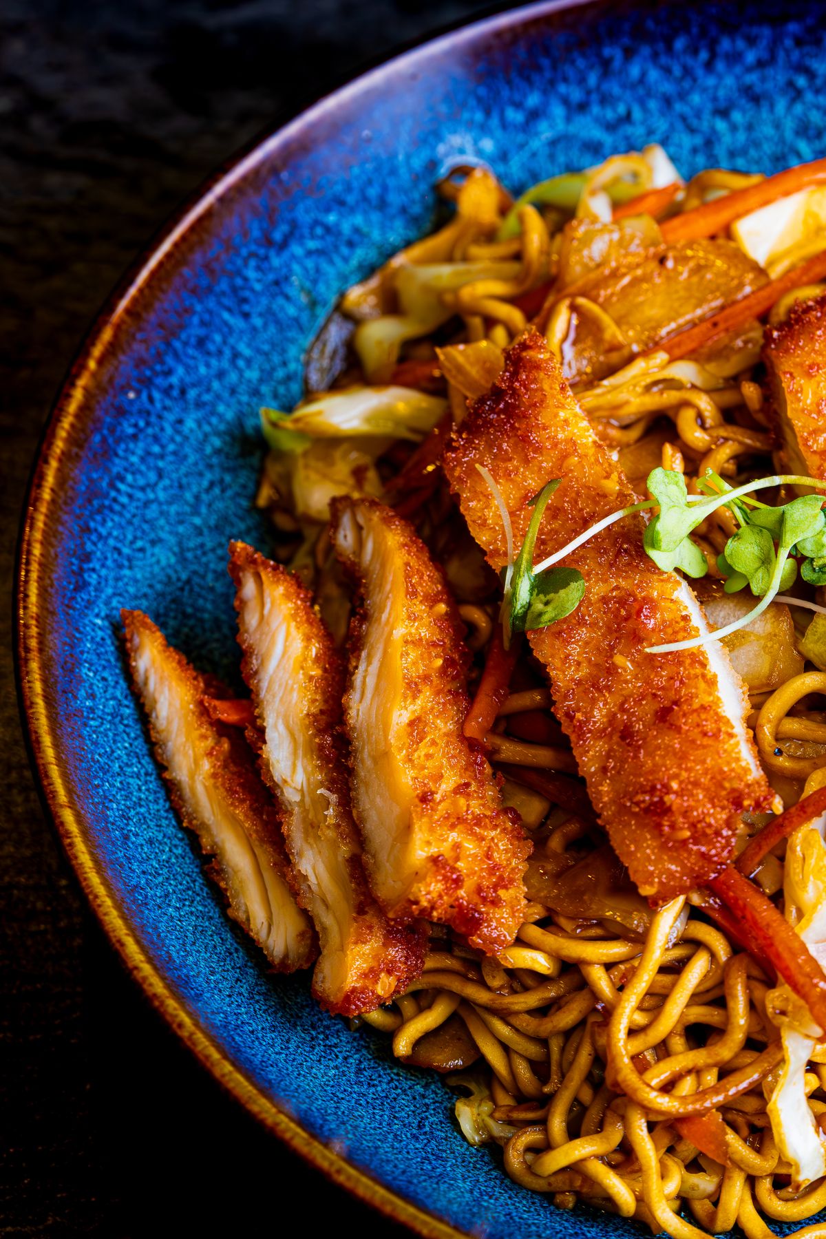 Roerbaknoedels met kimchi en varkensvlees in een wok