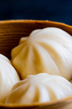Close-up of traditional steamed buns in a bamboo basket, perfect for food enthusiasts.