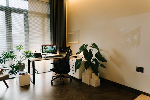 A stylish home office with contemporary furniture, lush plants, and ample natural light.