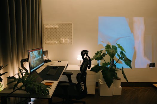 Cozy modern desk setup with plants and a projection on the wall, creating a serene work environment.