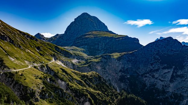 Breathtaking view of a mountain landscape with a winding path under clear blue skies.