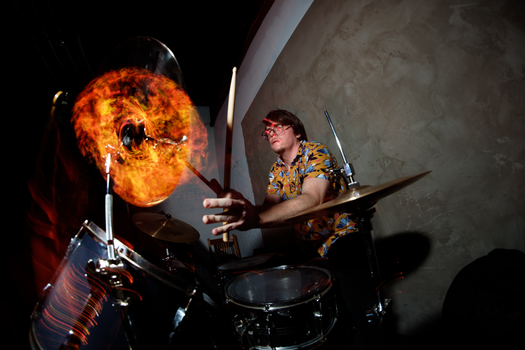 Energetic drummer performing with dynamic lighting effects, capturing the thrill of live music.