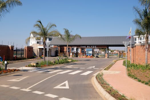 Entrance to The Blyde residential complex showcasing modern architecture and palm trees.