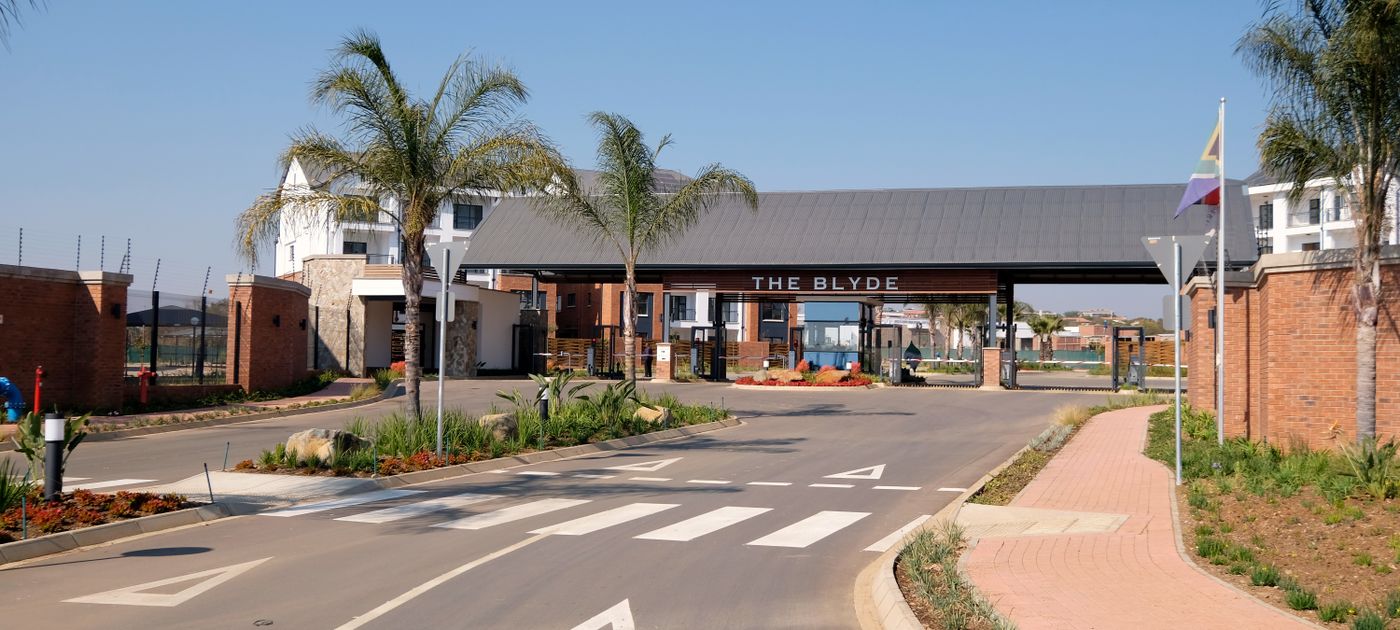 The entrance to a gated residential community — shared grounds and drains need coordinated pest control