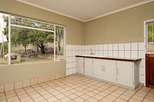 Empty kitchen interior with large window and garden view.
