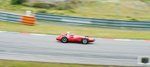 Free Classic red race car captured in motion during a high-speed track event. Stock Photo