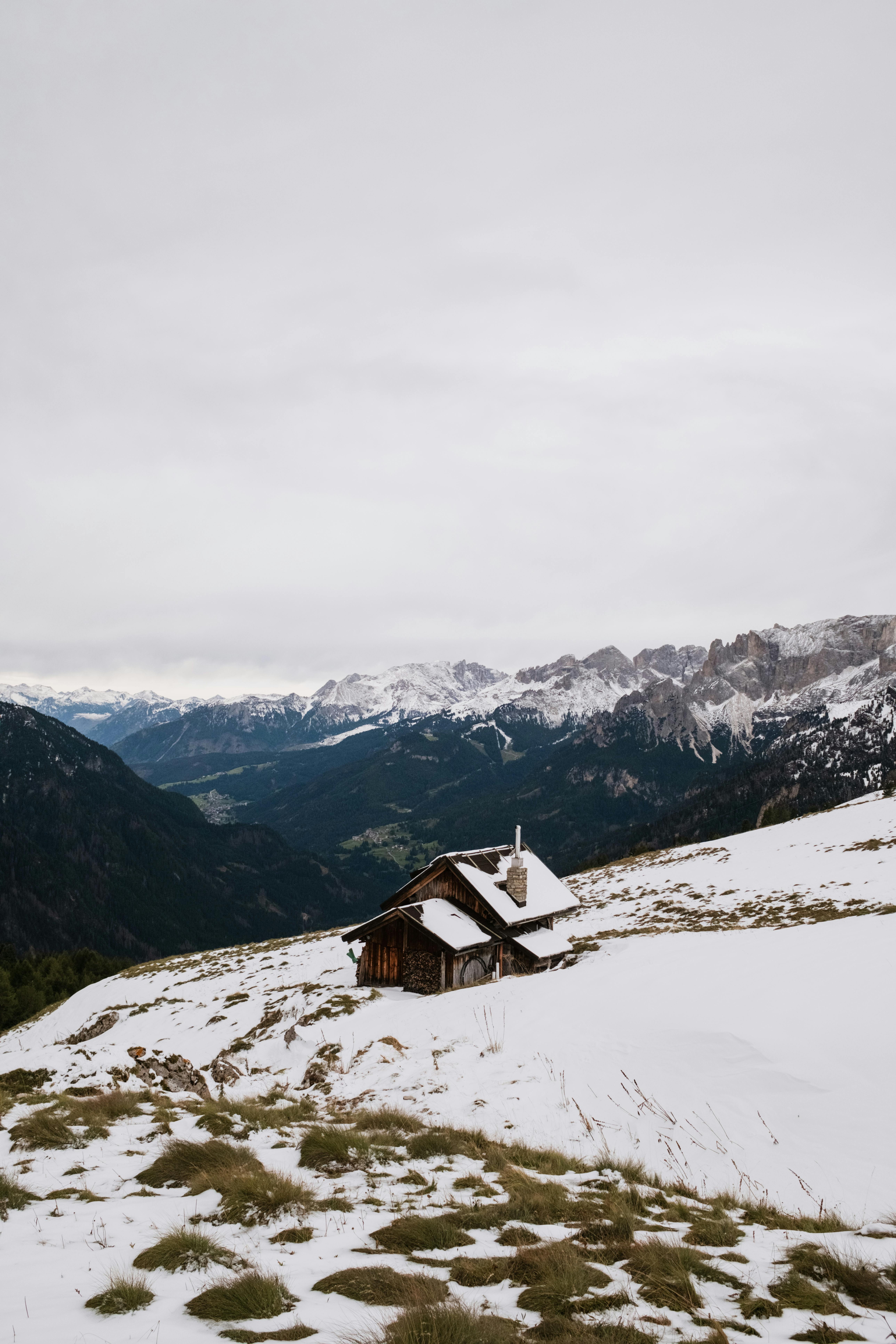 Charming snow-covered cabin in the Italian Alps, showcasing winter wonder in Canazei, Trentino.