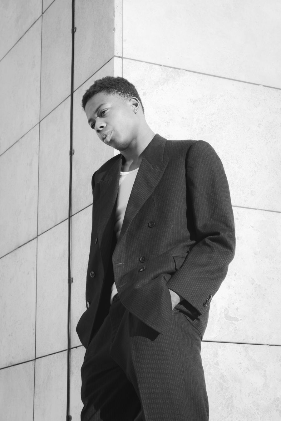 Tailored suit photographed against a bright wall in hard shadow