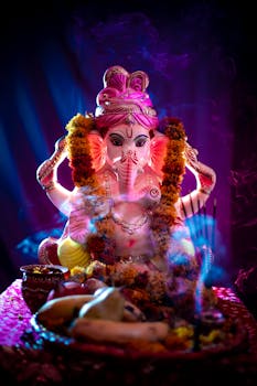 Colorful Ganesha idol with marigold garland and offerings, symbolizing Ganesh Chaturthi festival.