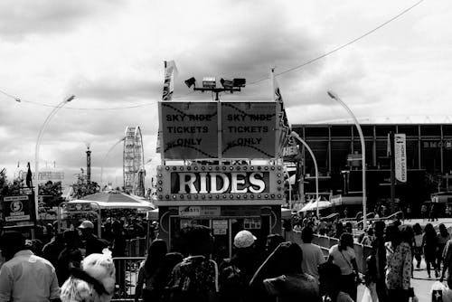 Free Grayscale Photography of Crowd Walking Near Rides Booth Stock Photo