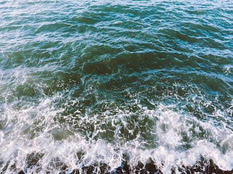 Captivating view of ocean waves on a sunny day at Old Colwyn Beach, Wales.