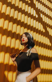 时尚女性与阳光明媚的黄色墙壁及流动的阴影相映成趣，营造出摩登而时尚的氛围