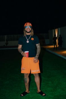 Man in casual attire enjoying a night outdoors with a red cup