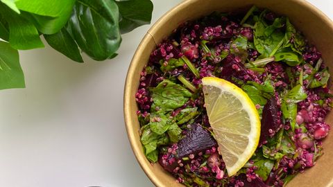 Vibrant beetroot salad with fresh greens and a lemon slice, perfect for a healthy meal.