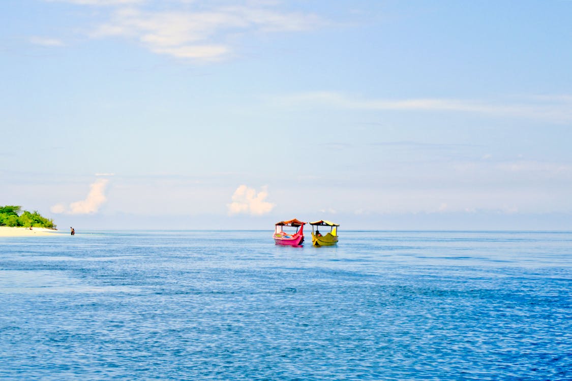Dua Perahu Berwarna Warni Di Laut Yang Tenang