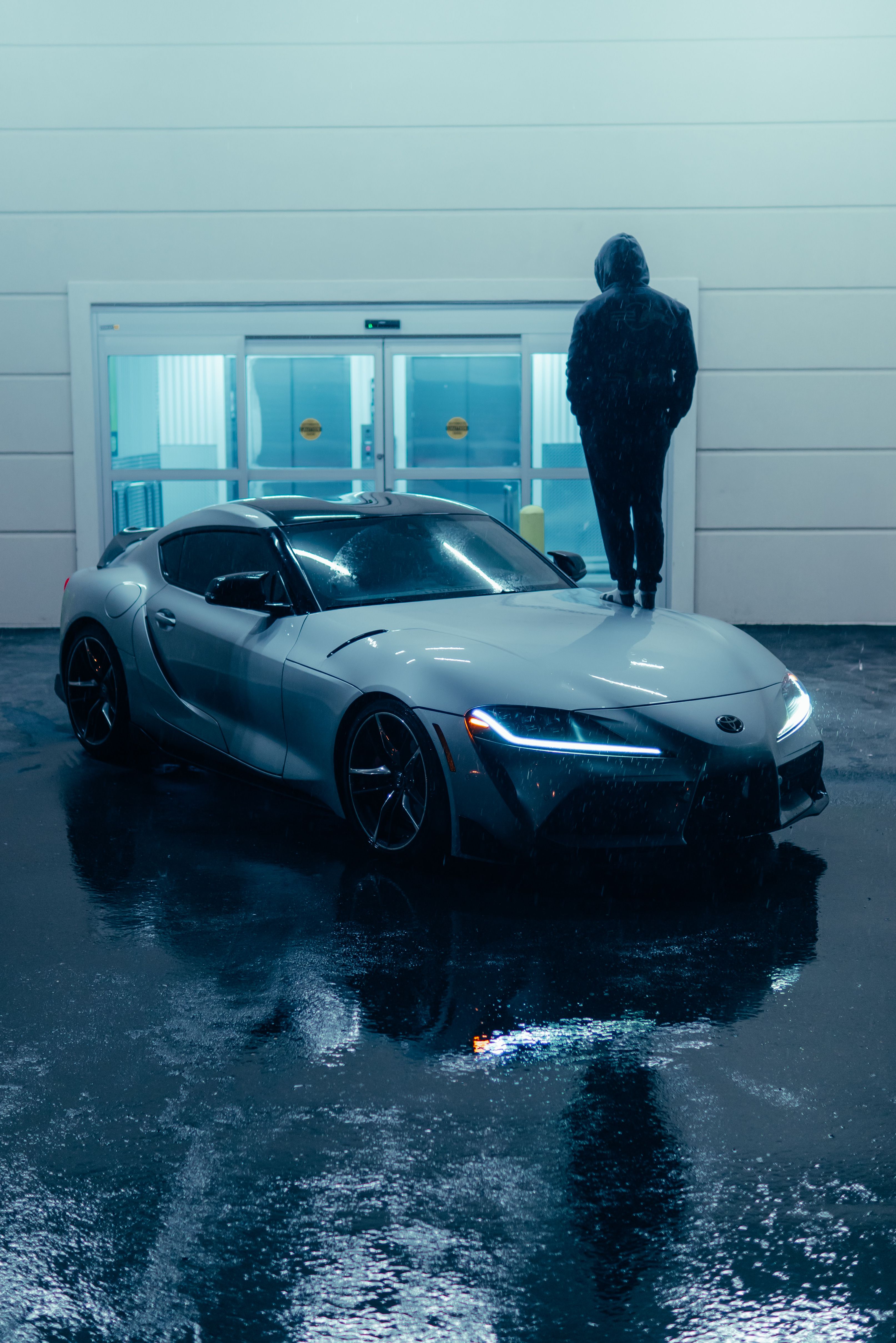 APEX GT-R silver grand tourer outside a modern concrete pavilion