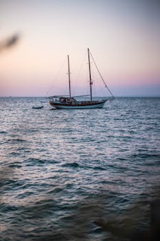 黄昏时分，一艘宁静的帆船漂浮在爱琴海上，捕捉着土耳其海岸线的宁静氛围