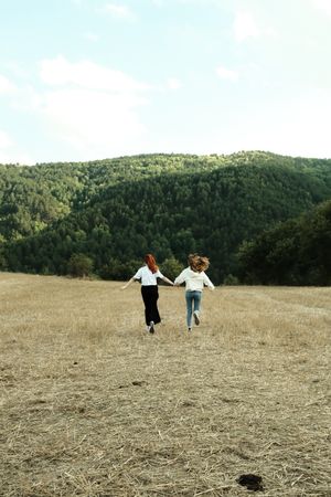 Two people running across an open field — photo by Sueda Dilli on Pexels