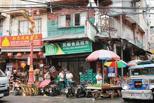 Free Vibrant market street in Manila's Chinatown with shops, vendors, and locals. Stock Photo