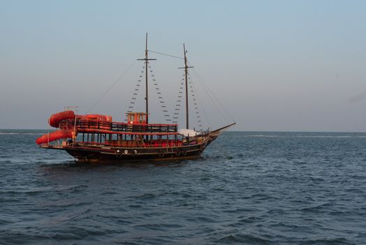 A traditional boat sailing on the serene ocean in Porto Seguro, Brazil.