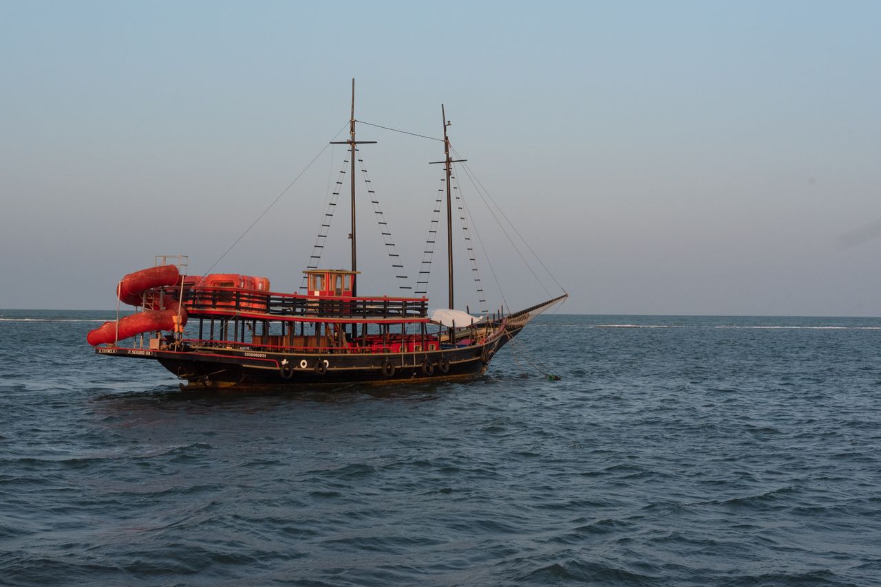 a traditional boat sailing on the serene ocean in porto seguro brazil