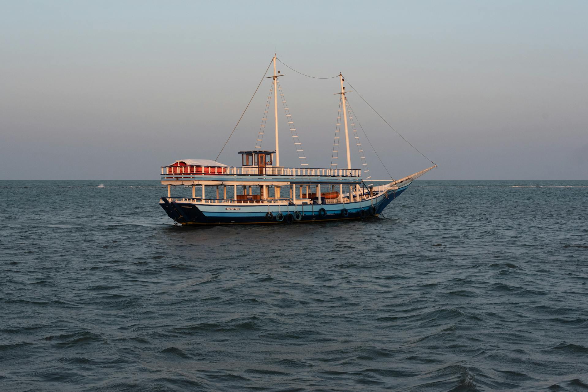 A traditional schooner sails calmly on the ocean near Porto Seguro at sunset.